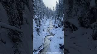 Beauty Of Nature. Beautiful Stream Flowing Through Snow Covered Trees.