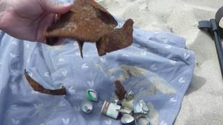 Beach search with a metal detector. Beach full of iron