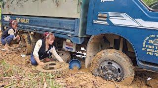 Girl repairs and restores a broken car wheel in the middle of the road.