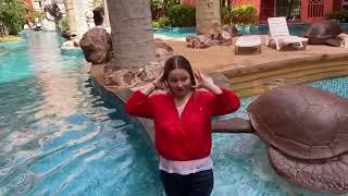 in the pool in jeans and a red windbreaker