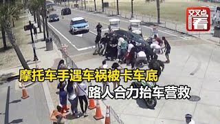 【交叉点评】监控录像记录全过程！摩托车手遇车祸被卡车底，路人合力抬车营救。