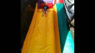 Finny sliding down the bounce house.