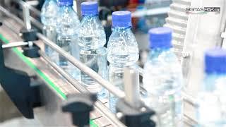 Packaging equipment. Filling into PET bottles with 28mm cap closures on Tribloc equipment