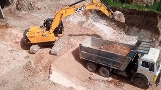 JCB Backhoe loading earth to dump trucks