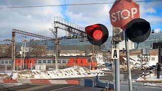 Railway crossing with a barrier in winter / Passenger trains, commuter trains, Aeroexpress