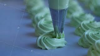 Squeeze the cream filling on the green cupcake, closeup