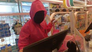 Cashier with pink custome and full face black mask