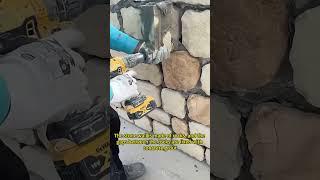 The stone wall is made of rocks, and the gaps between the rocks are fixed with concrete grout