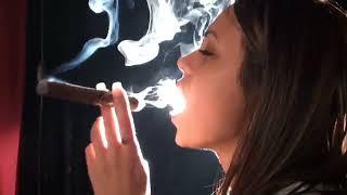 A YOUNG GIRL IS SMOKING CIGAR