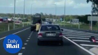 Shocking footage shows woman hanging out the window of a moving car