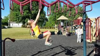 Girl dominates monkey bars.