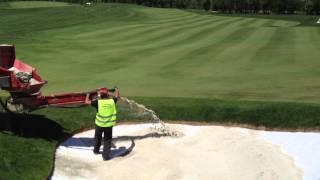 Descarga de arena en bunker mediante recebadora / Bunker sand installation with fairway topdresser