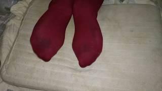 Girl dirty red socks trample and footrest on pillow