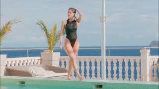 Melisa Mendini One-Piece Black Swimsuit Body Forwarded-and-Backwarded Outside Hot Tub Resort Scene