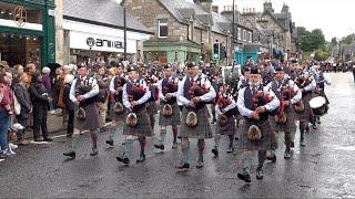 Arbroath and Perth Pipe Bands playing in street parade march to 2024 Pitlochry Highland Games