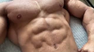 Alpha muscle Rodrigo Calvancanti laying down and showing off his muscular upper body