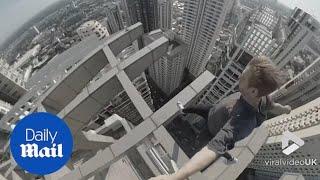 Adrenaline junkie leaps across beams hundreds of feet above street