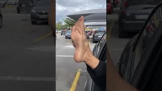 Candid feet soles out of the car window