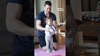 Toddler Girl Does Stretching Exercises at Home With Dad's Help