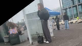 young blond girl candid smoking at the bus stop