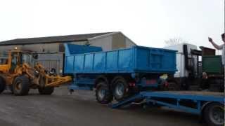 NEW HOOKLIFT TRAILER BEING LOADED ON TO LOW LOADER WAGON