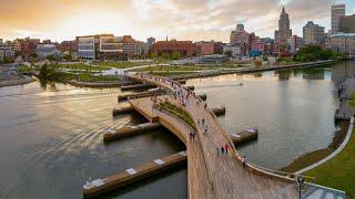 Curved pedestrian bridge links two riverfront parks in Providence