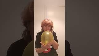 blowing up a gold balloon