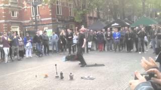 Guy goes through tennis racket while balancing ball on head