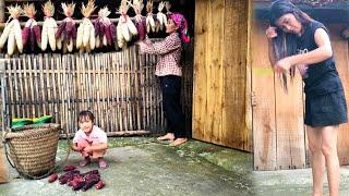 Mother and daughter bundle corn into bunches and hang them on the wall to dry naturally,storing food