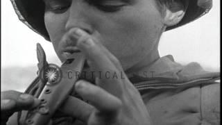 A GI plays an ocarina and a troop transport is loaded with soldiers in Anzio, Ita...HD Stock Footage