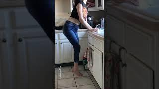 Girl pees in pants while doing dishes