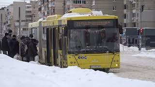 Bus MAZ 215 in winter Kyiv, at a stop. Passengers board. A huge yellow bus