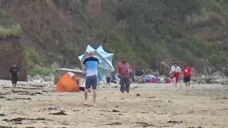 Dan chasing the umbrella down the beach