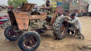 An expert mechanic repairs a rusty tractor that has been left in the rain for years