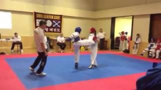 Boy getting kicked in face by girl at Taekwondo competition