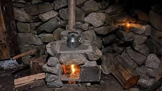 A man restores a stone hut in the mountains. Builds a fireplace. Overnight in solitude.