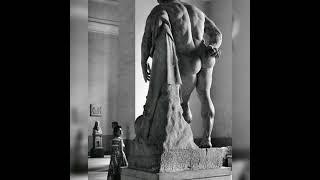 a woman looking up at the Farnese Hercules, a Roman sculpture from the early third century A.D. ...