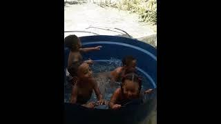 as crianças tomando banho dentro da caixa d'água
