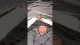 Car camping in a blizzard by a mountain lake in New Zealand.