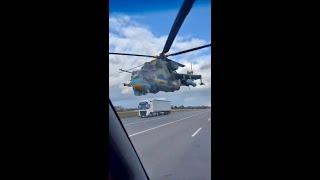 Incredible flight of a Ukraine Mi-24 helicopter  just  above a car + truck  filled highway