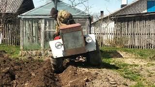 Гусеничный минитрактор пашет огород .