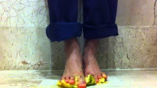 Male feet. Barefoot orange crushing