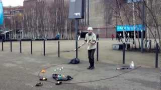 A juggler is playing with fire near Tate Modern, London.