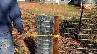 Homemade fence stretcher with 2x4s.  Works amazing!