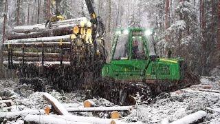 John Deere 1110E logging in snowy winter forest, big load