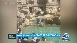 Tourist walks across Trevi Fountain in Rome to fill water bottle