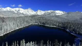 Aerial drone flight over a wintry snow covered lake in the Colorado Rocky Mountains in winter