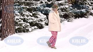 Beautiful happy girl walks in the frosty winter forest