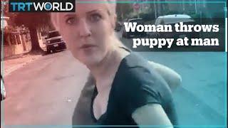 Woman harasses man and throws a dog at him