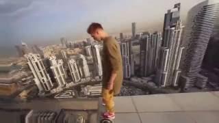 Crazy guy play hoverboard on the extreme edge of skyscraper roof